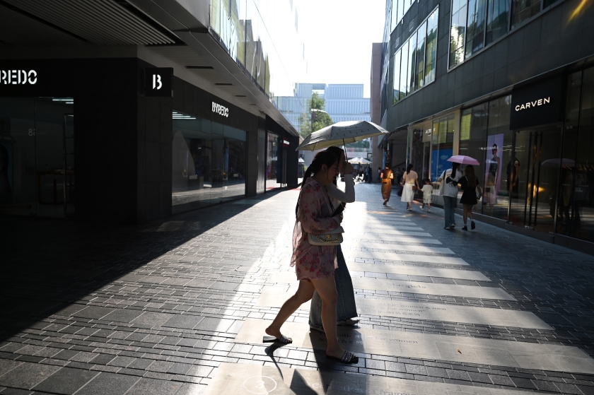 Una mujer cruza una calle de la ciudad en medio de altas temperaturas