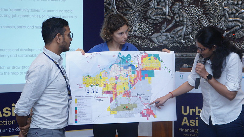 los participantes en el curso de adaptación al crecimiento urbano examinan un mapa de ejemplo de una zona urbana en expansión