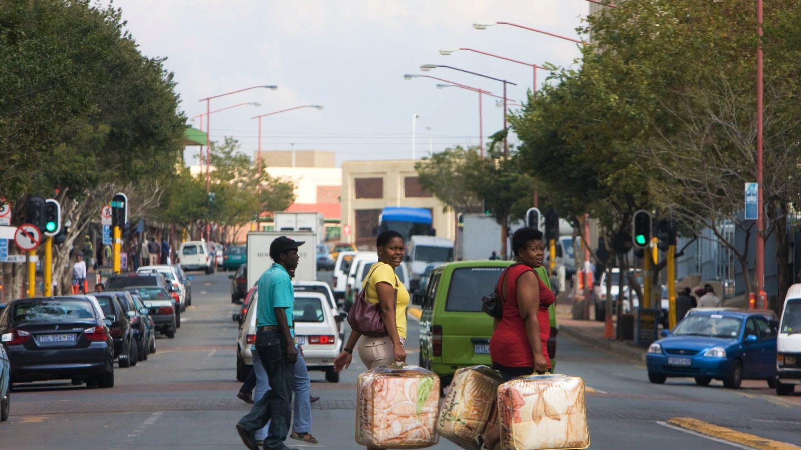 Gente cruzando una calle muy transitada en Johannesburgo, Sudáfrica