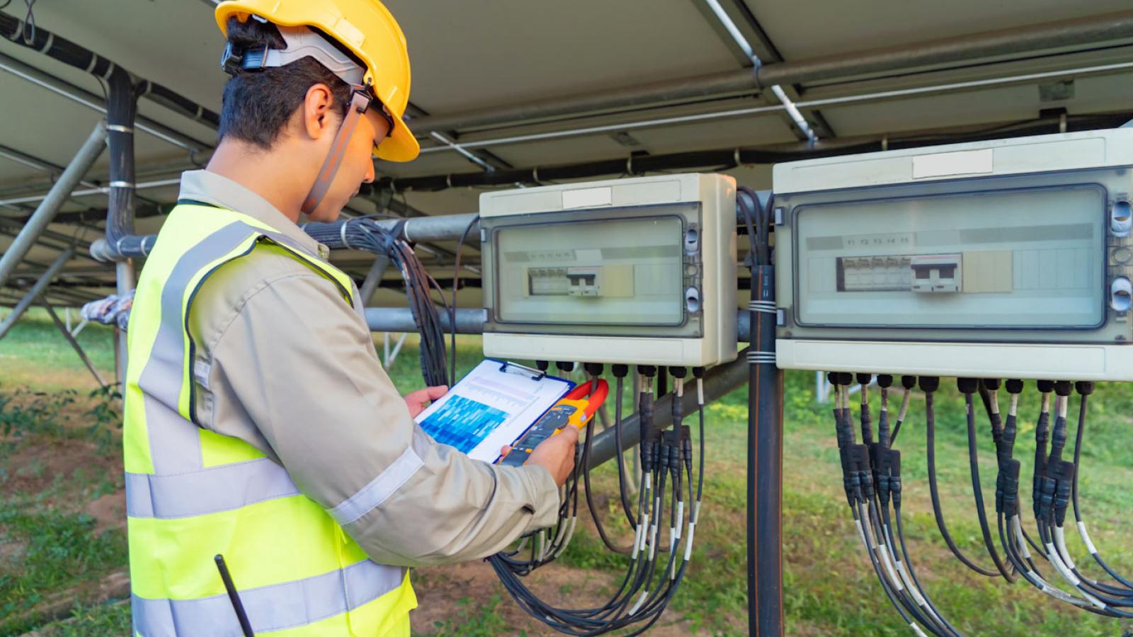 Hombre comprobando datos en la parte trasera de una central solar