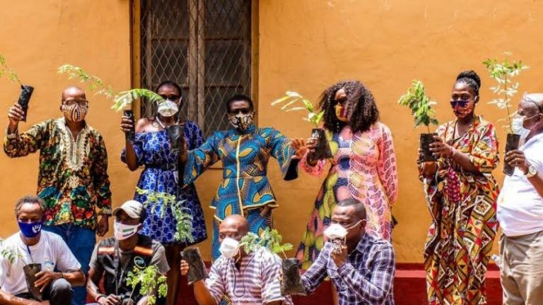 Un grupo de residentes de Freetown posa con sus plantones