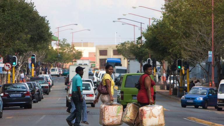 Gente cruzando una calle muy transitada en Johannesburgo, Sudáfrica
