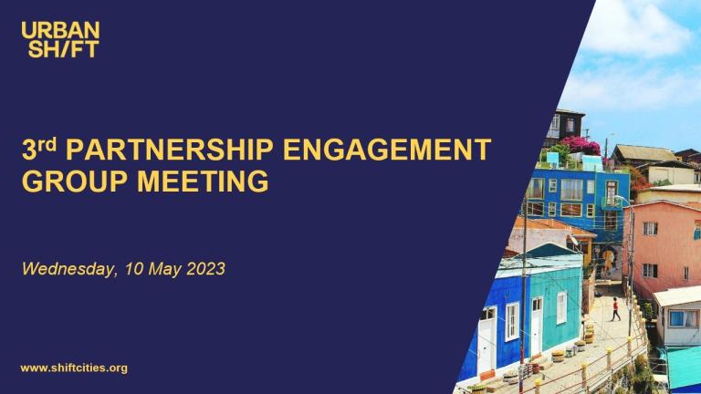 una diapositiva con el texto 3rd partnership engagement group meeting sobre fondo azul marino; a la derecha, una imagen de edificios de colores vivos