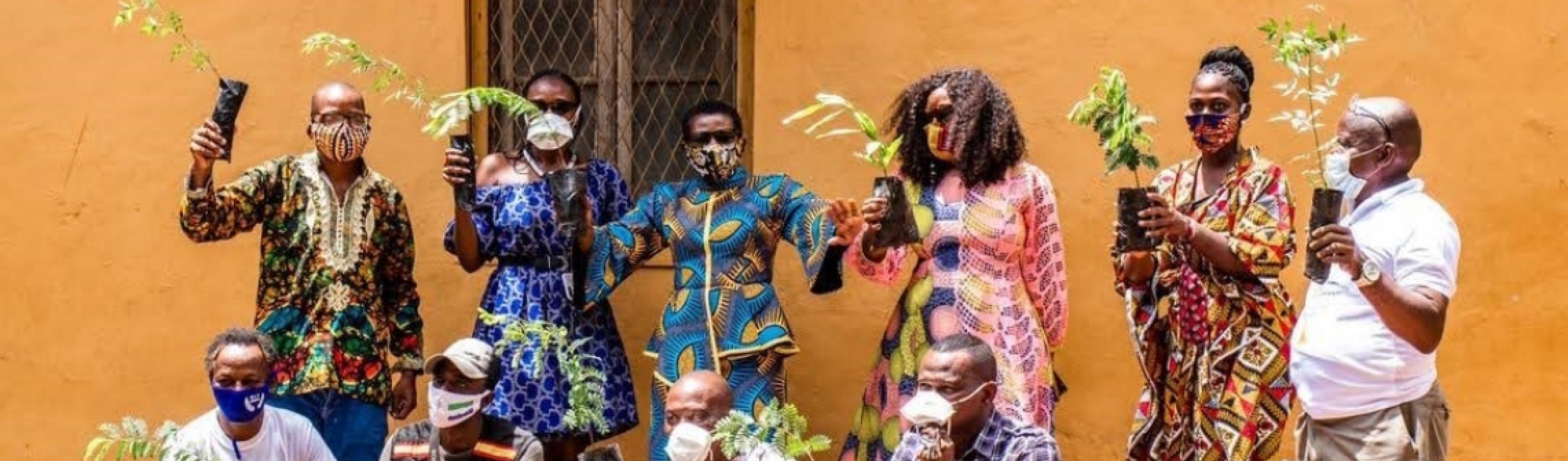 Un grupo de residentes de Freetown posa con sus plantones