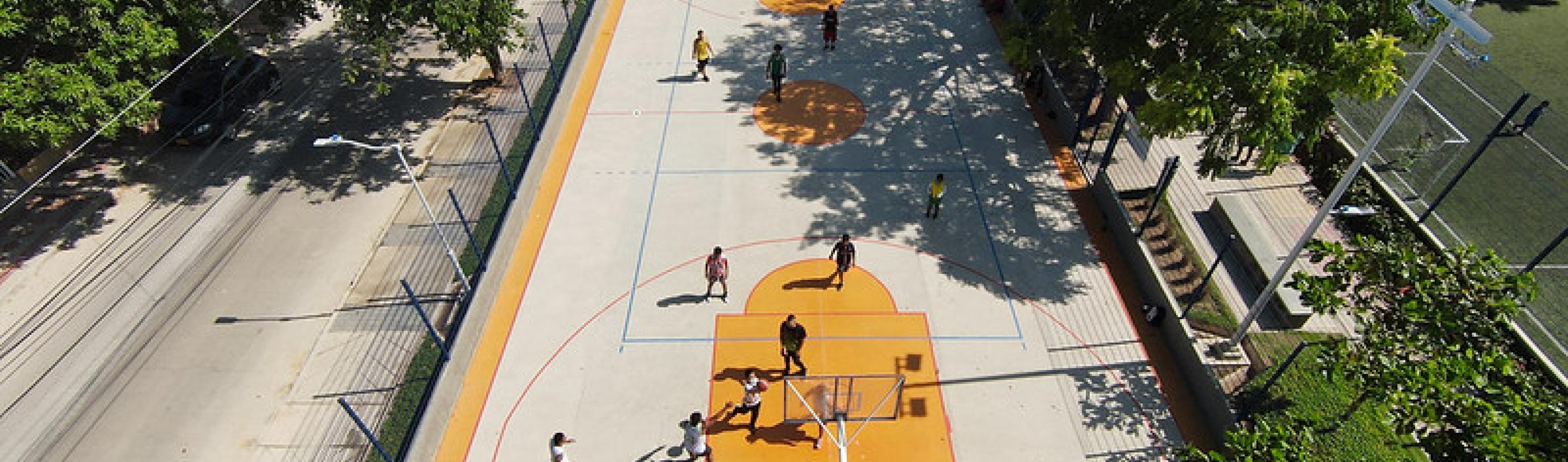Vista aérea de una cancha de baloncesto rodeada de árboles en Barranquilla, Colombia.